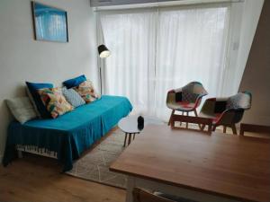 un salon avec un canapé, des chaises et une fenêtre dans l'établissement Bananec- Appt à 300 mètres de la plage, à La Forêt-Fouesnant