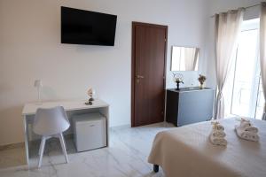 a bedroom with a bed and a desk and a television at IL GIGLIO b&b in Recale