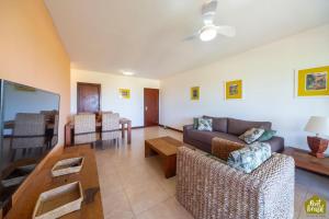 a living room with a couch and a table at Reserva Imbassaí - Apartamento TD 11 02 Superior - Buganvílias in Imbassai