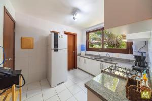 a kitchen with a refrigerator and a sink at Reserva Imbassaí - Apartamento TD 11 02 Superior - Buganvílias in Imbassai +36 photos