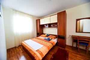 a bedroom with a bed and a desk and a mirror at Apartments Ivan in Zadar