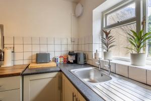 a kitchen counter with a sink and a window at Large House, Garden, 3 Bedrooms in Bristol +24 photos