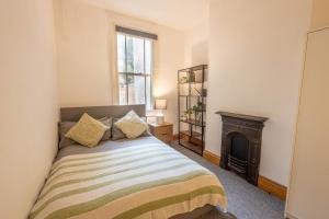 a bedroom with a bed and a fireplace at Large House, Garden, 3 Bedrooms in Bristol