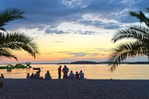 - un groupe de personnes debout sur une plage au coucher du soleil dans l'établissement Ferienhaus für 6 Personen ca 90 qm in Krnica, Istrien Bucht von Raša, à Krnica