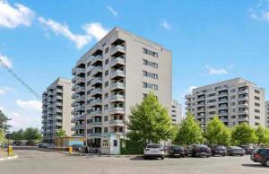 VoluntariにあるCozy Flat North Bucharestの駐車場に車が駐車されている高層ビル