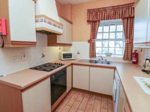 una cucina con lavello e fornelli forno a legna di Primula Patch a Wooler
