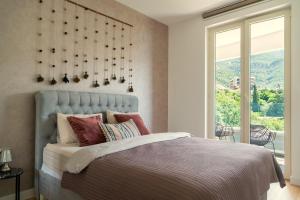 a bedroom with a bed and a large window at The Dream Getaway SkyLine by DeVasco in Bečići