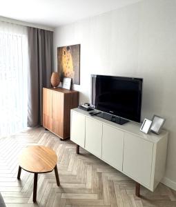 una sala de estar con TV en un armario blanco en Apartament Śnieżny, en Karpacz