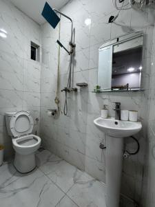 a white bathroom with a toilet and a sink at Prime OAK Residence in Lagos