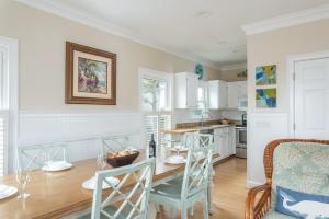 a dining room with a table and chairs and a kitchen at Shipwatch Beach House - Ocean Views! Shared Pool! in Cedar Reef Villas