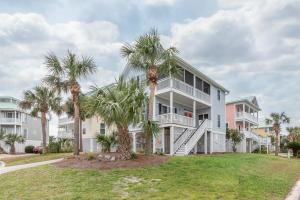 a large house with palm trees in front of it at Shipwatch Beach House - Ocean Views! Shared Pool! in Cedar Reef Villas