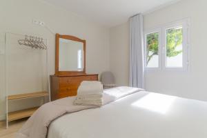 una camera da letto bianca con un letto grande e uno specchio di Casa da Hortência do Faial a Faial Altre 21 foto