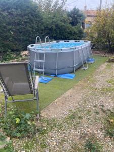 a hot tub in a yard with a chair at Villa Sorgues in Sorgues