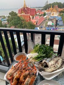 two plates of food on a table on a balcony at Beach Front Condo Centerviews Bangsaray Floor 7 in Bang Sare