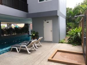 a patio with lounge chairs and a swimming pool at Beach Front Condo Centerviews Bangsaray Floor 7 in Bang Sare