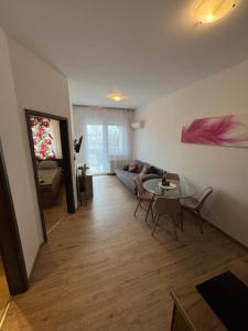 a living room with a couch and a table at AH-Corso Wellness Panorama Apartman in Siófok