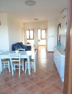 a kitchen and dining room with a table and chairs at La Pelosa House 1 in Stintino
