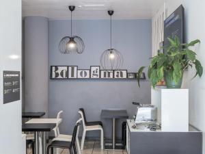 restauracja ze stołami i krzesłami oraz dwoma lampkami wiszącymi w obiekcie B&B HOTEL Bologna w mieście Castel Maggiore