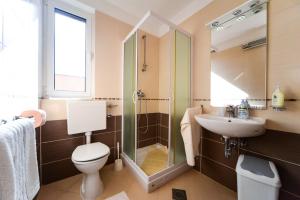 a bathroom with a toilet and a sink and a shower at Apartments Ivan in Zadar +70 photos