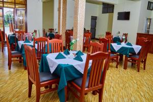a dining room with blue and white tables and chairs at KiliCrane Lodge Arusha in Arusha