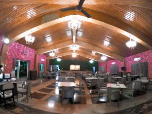 a dining room with tables and chairs and a ceiling at Whispering Woods Resort in Lonavala