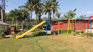 a playground with a yellow slide in a yard at Whispering Woods Resort in Lonavala