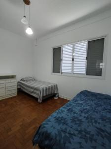 a bedroom with two beds and two windows at Apto/garagem coberta/900m-Centro in Registro