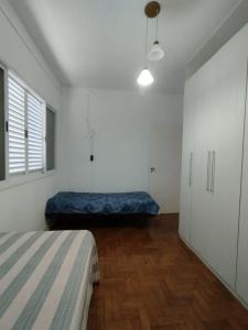 a bedroom with a bed in the corner of a room at Apto/garagem coberta/900m-Centro in Registro
