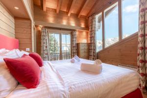 een slaapkamer met een groot bed met rode kussens bij Natasha EXCEPTIONAL & LUXE chalet 12 pers by Alpvision Résidences in Plan Fey