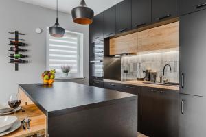 a kitchen with black cabinets and a black counter top at Lumina luxury 3-rooms apartments with parking in Łódź