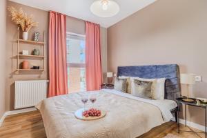 a bedroom with a bed with two glasses of wine at Lumina luxury 3-rooms apartments with parking in Łódź