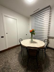 a room with a table with a vase of flowers on it at La casa dei miei in Bologna +2 photos