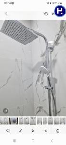 La salle de bains est pourvue d'une douche et d'un mur en marbre. dans l'établissement Appartement saidia 3 chambre à 150 m de la plage, à Saïdia