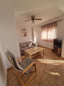 a living room with a chair and a couch at 3ºB Escobar in Nerja