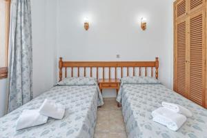 a bedroom with two beds and a table at Apartamento La Cabanya 1a in Canyamel +16 photos