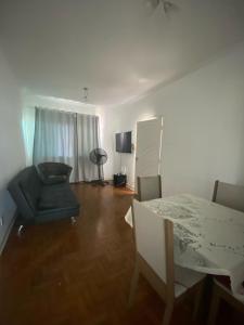a living room with a table and chairs and a television at Apto/garagem coberta/900m-Centro in Registro