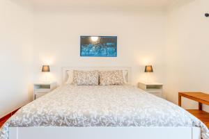 a bedroom with a white bed with two lamps at CAIS APARTMENT by Stay in Alentejo in Vila Nova de Milfontes
