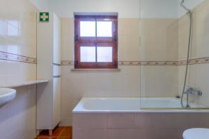a bathroom with a tub and a sink and a window at CAIS APARTMENT by Stay in Alentejo in Vila Nova de Milfontes +22 photos