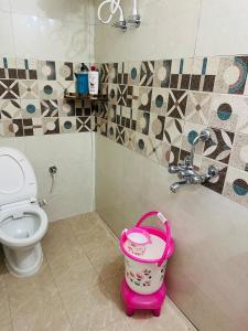 a bathroom with a toilet and a bucket at Kamaree-7BHK in Varanasi