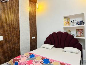 a bed with a red headboard in a room at Kamaree-7BHK in Varanasi