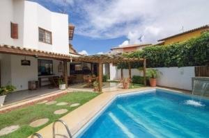 a swimming pool in the backyard of a house at Casa de Praia em Guarajuba-Genipabu-BA in Guarajuba