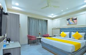 ニューデリーにあるHotel Sapphire House - 3 Mins Walk from Metro and 5 Mins from Rail Stationのベッドとテーブルと椅子のあるホテルの部屋