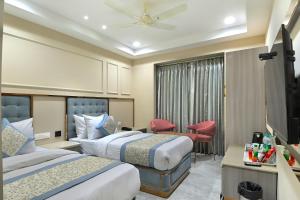 ニューデリーにあるHotel Sapphire House - 3 Mins Walk from Metro and 5 Mins from Rail Stationのベッド2台とテレビがあるホテルの部屋