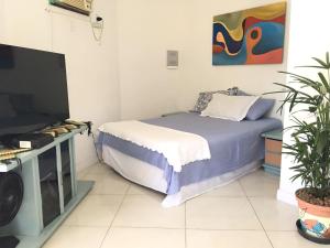 a bedroom with a bed and a flat screen tv at Suíte FAMILIAR Varandão Aeroporto Internacional in Rio de Janeiro