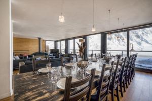 a dining room with a long table and chairs at Chalet Arktic - Catered Chalet - Sleeps 14 in Tignes