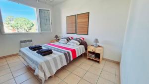 une chambre avec un grand lit avec une fenêtre dans l'établissement Villa LA DIVA Agréable villa familiale climatisée proche plage - 3 chambres - jardin et terrasse, à Saint Cyprien Plage