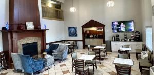 a restaurant with a fireplace and tables and chairs at Baymont by Wyndham Litchfield in Litchfield