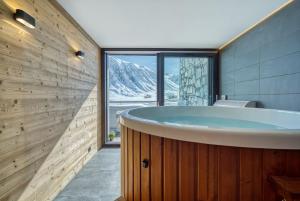 a bathroom with a tub with a mountain view at Chalet Arktic - Catered Chalet - Sleeps 14 in Tignes +23 photos