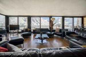 a living room with couches and a television and mountains at Chalet Arktic - Catered Chalet - Sleeps 14 in Tignes