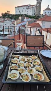 a tray of food on top of a table with a glass of wine at Apartment Tartini Piran exclusive rooftop penthouse in Piran